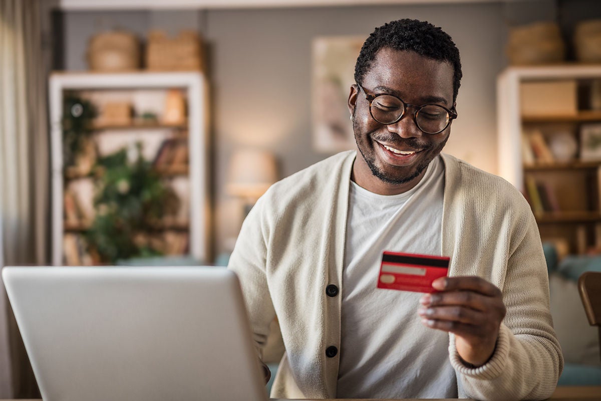 Portrait of happy black young man paying online
