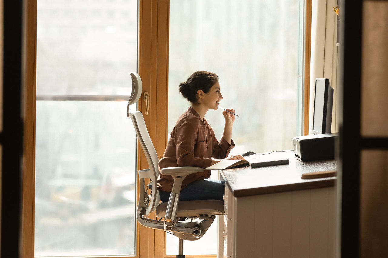 Seated job seeker browsing career opportunities on her PC. 