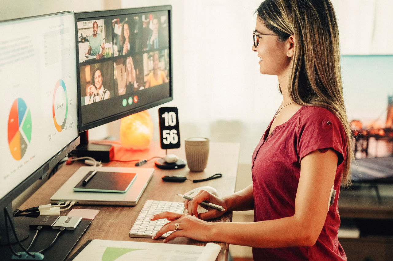 Woman sharing a presentation while videoconferencing from a home office. 