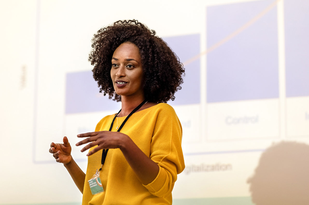 Speaker standing in front of a screen to present a workshop.