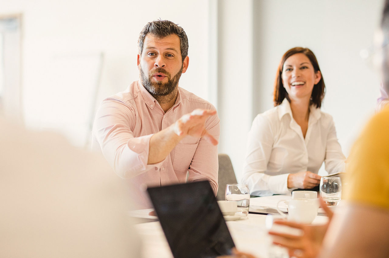 Seated man speaking during a meeting.