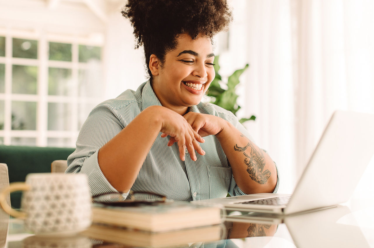 Woman seated in a home office and videoconferencing with a colleague.