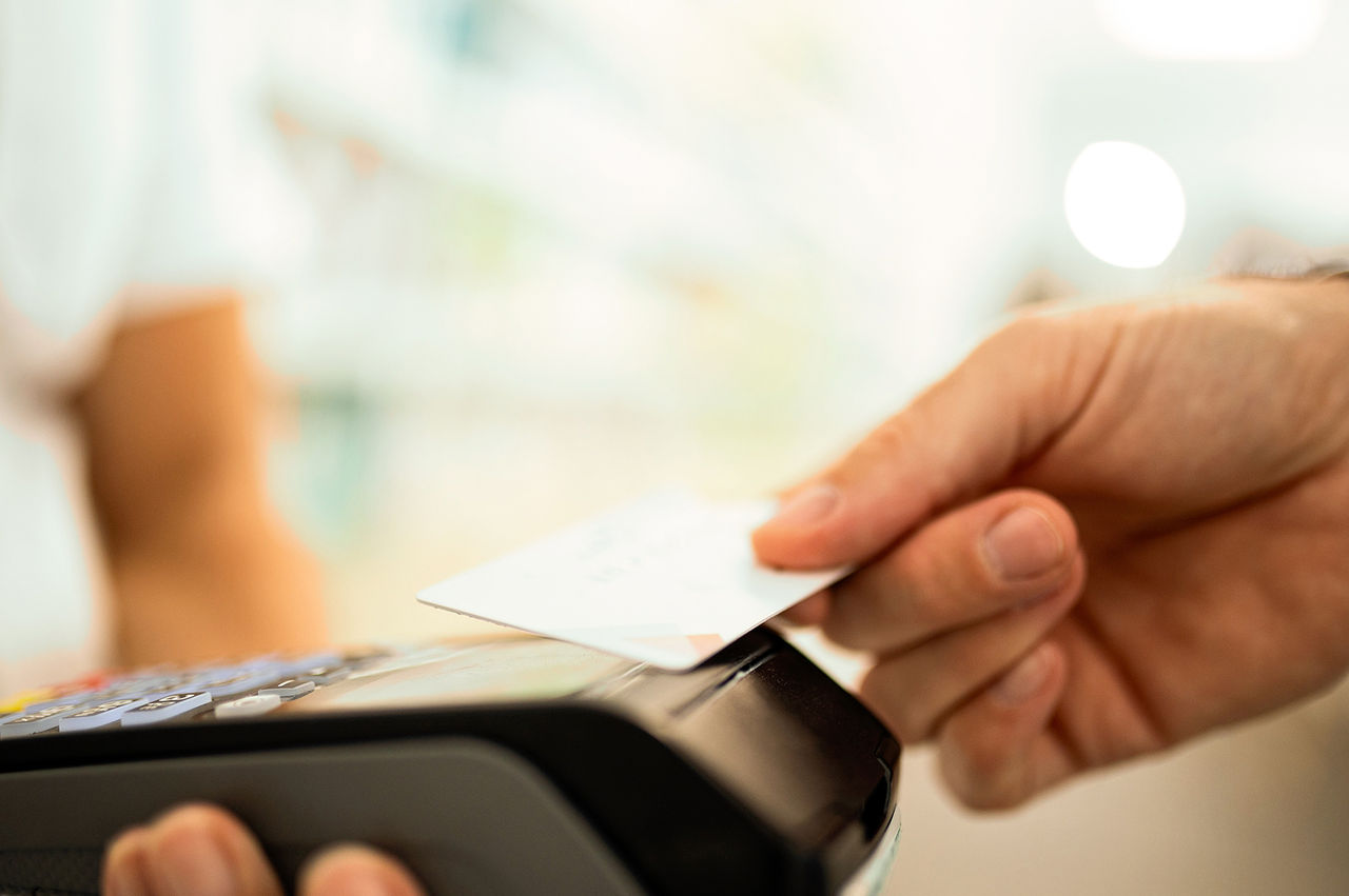 Retail customer tapping his debit card on a POS system. 