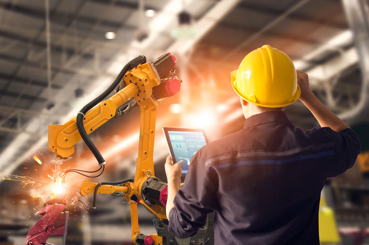 Man inspecting machinery in warehouse.